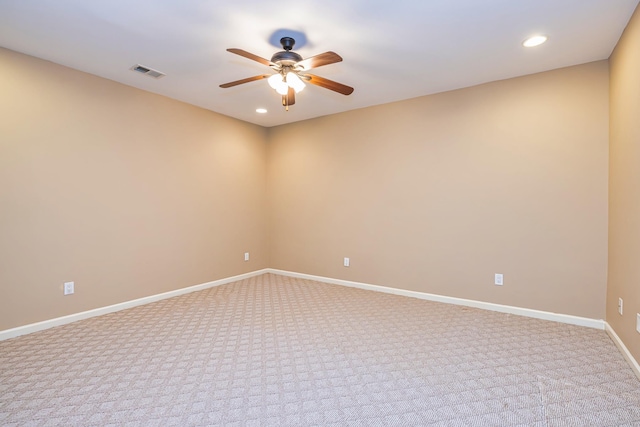 spare room featuring light colored carpet and ceiling fan