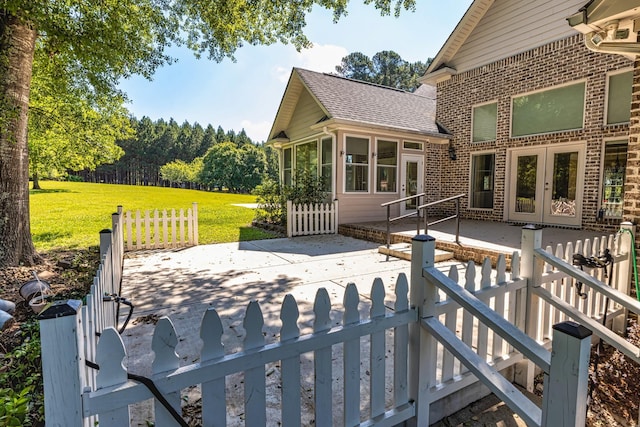 wooden terrace featuring a yard, a patio area, and french doors