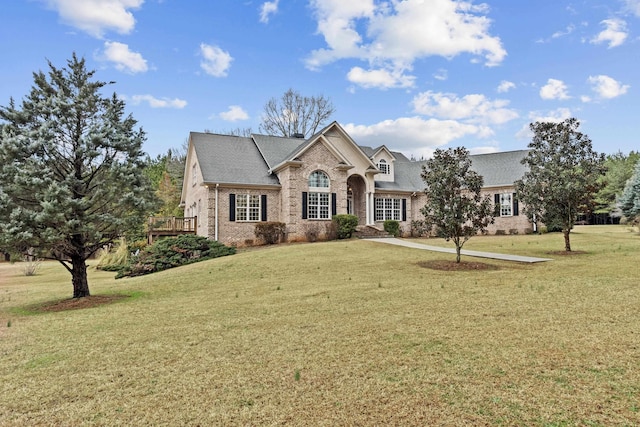 view of front of home with a wooden deck and a front lawn