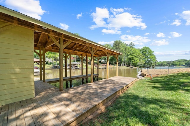 dock area featuring fence, a lawn, and a water view