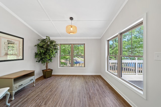 interior space featuring wood finished floors, baseboards, and ornamental molding