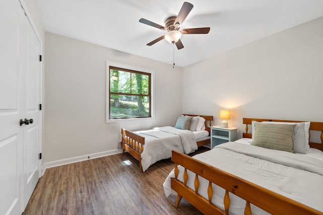 bedroom featuring wood finished floors, baseboards, and ceiling fan
