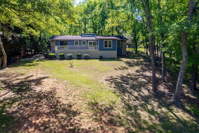 view of front of property with a forest view, a front yard, and fence