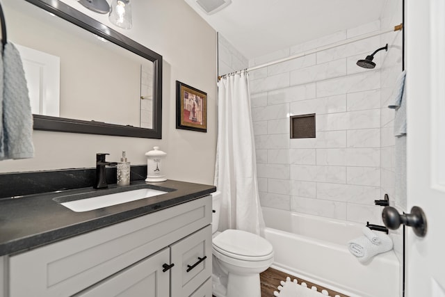 full bathroom featuring shower / bath combo with shower curtain, toilet, vanity, and visible vents