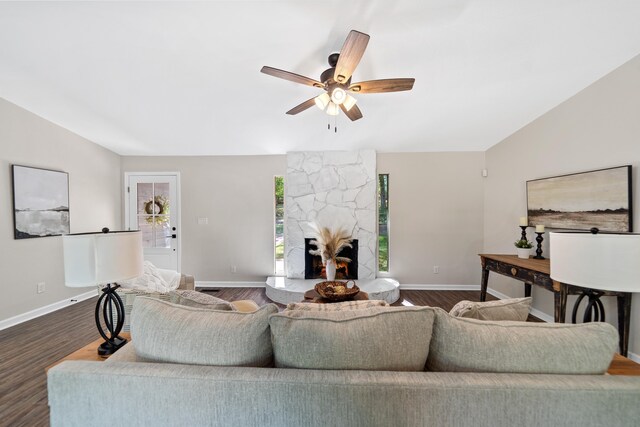 living area with a fireplace, baseboards, a ceiling fan, and dark wood-style floors