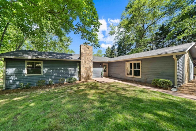 view of front of home with a front lawn and a chimney