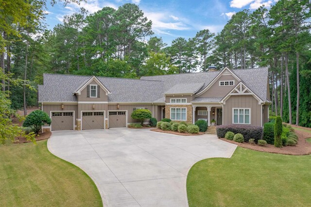 craftsman inspired home featuring a garage and a front yard