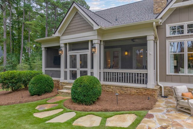 rear view of house featuring a sunroom and a patio area