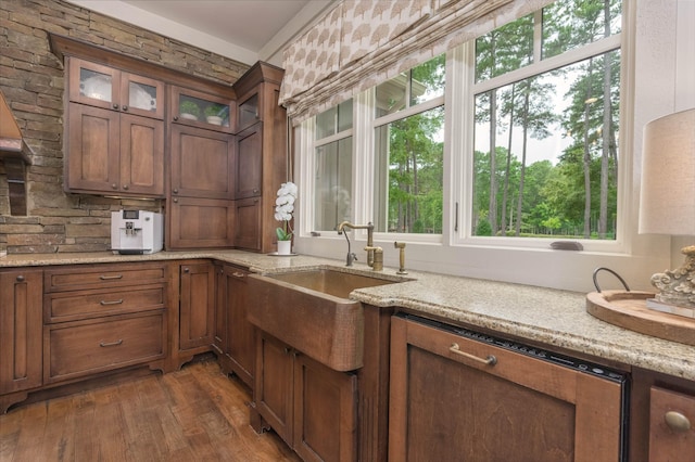 kitchen with light stone counters, dark hardwood / wood-style floors, and sink