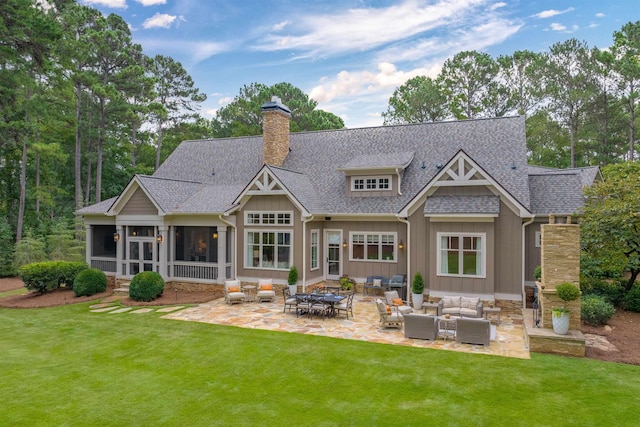 back of house featuring an outdoor living space, a patio, a sunroom, and a yard