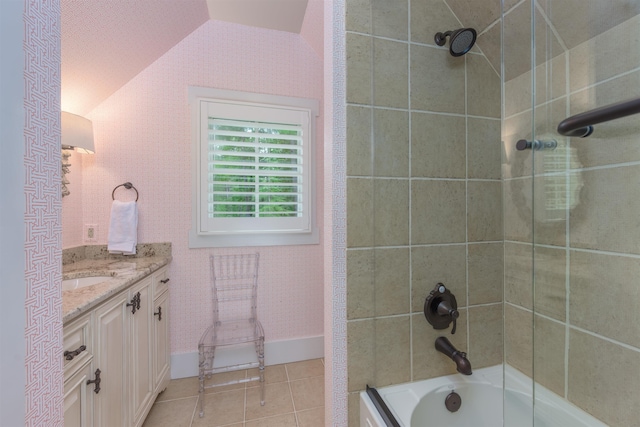 bathroom with tile patterned floors, vanity, tiled shower / bath combo, and vaulted ceiling