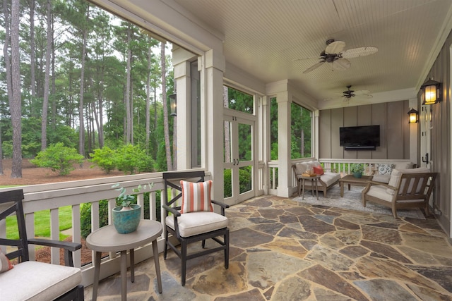 sunroom / solarium featuring ceiling fan