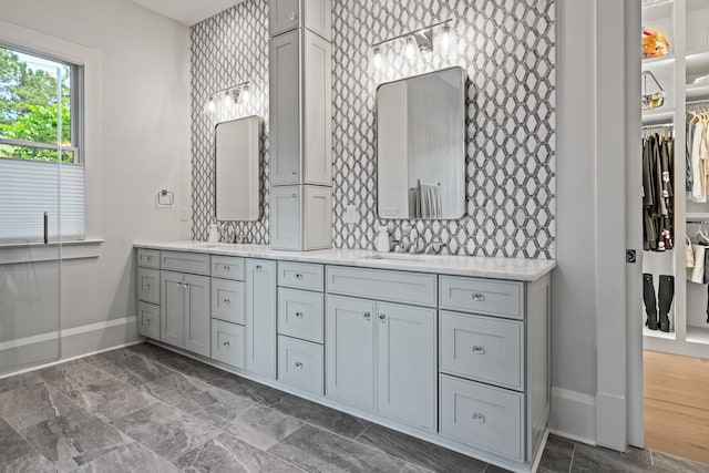 1101 Brookside, Greensboro, GA 30642 - bathroom featuring a walk in closet, tasteful backsplash, baseboards, a sink, and double vanity