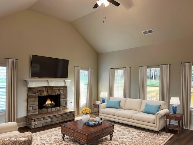 living room with visible vents, ceiling fan, wood finished floors, a fireplace, and high vaulted ceiling