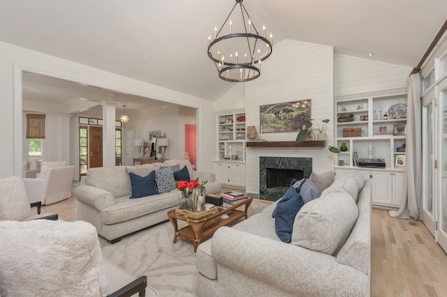 1040 Kimbrough Hill Ln, Greensboro, GA 30642 - living area with vaulted ceiling, a chandelier, light wood-type flooring, built in features, and a high end fireplace
