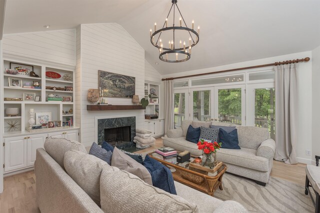 1040 Kimbrough Hill Ln, Greensboro, GA 30642 - living area with light wood finished floors, a chandelier, a premium fireplace, built in features, and high vaulted ceiling