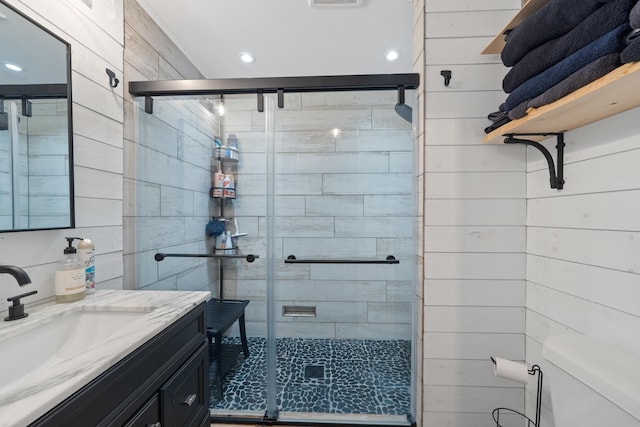 full bathroom with toilet, a stall shower, recessed lighting, wood walls, and vanity