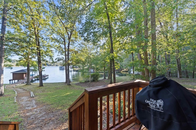 wooden terrace with grilling area, a water view, a lawn, and a boat dock