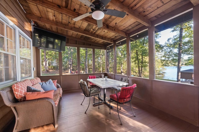 sunroom with vaulted ceiling, wood ceiling, a ceiling fan, and a water view