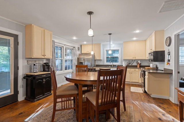 dining room with dark wood finished floors, a healthy amount of sunlight, and visible vents