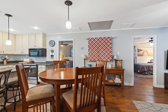 dining room with visible vents, crown molding, baseboards, dark wood-type flooring, and ceiling fan