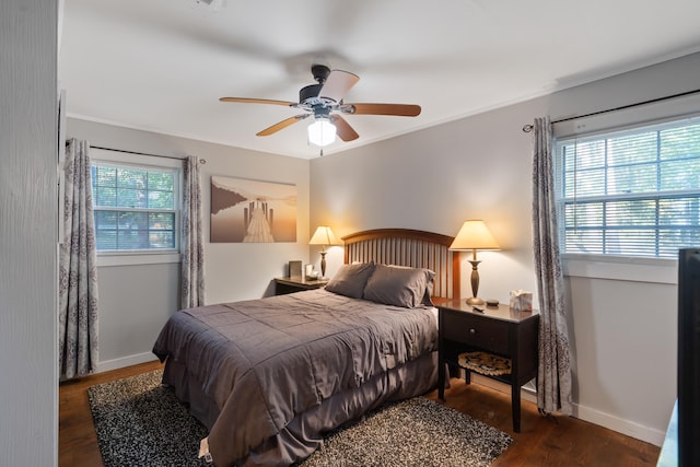 bedroom featuring a ceiling fan, crown molding, baseboards, and wood finished floors