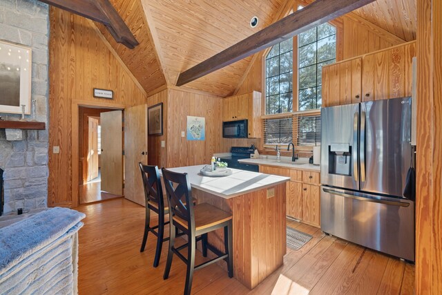 125 Secoffee Dr, Eatonton, GA 31024 - kitchen with black microwave, wood walls, beamed ceiling, and stainless steel refrigerator with ice dispenser