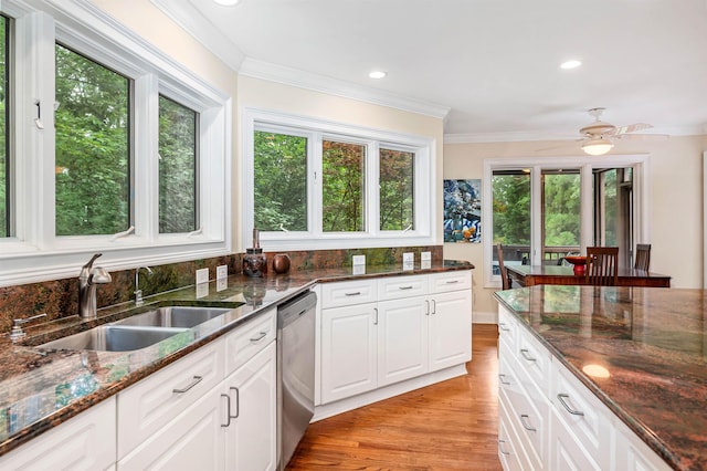 kitchen with sink, crown molding, dishwasher, white cabinetry, and dark stone counters