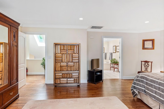 bedroom featuring ornamental molding, hardwood / wood-style floors, and a skylight