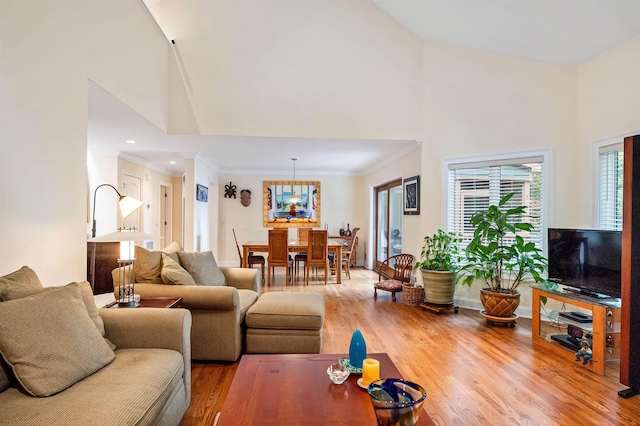 living room featuring hardwood / wood-style floors, crown molding, and high vaulted ceiling