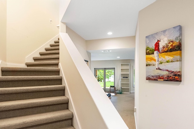 stairway featuring carpet