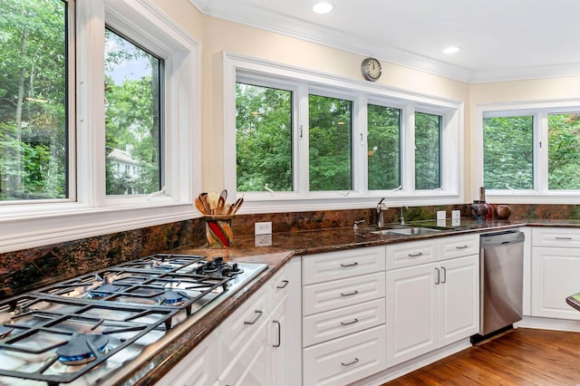 kitchen with sink, crown molding, stainless steel appliances, white cabinets, and dark stone counters