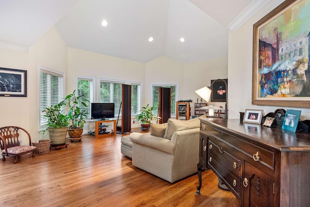 living room with crown molding, light hardwood / wood-style flooring, and high vaulted ceiling