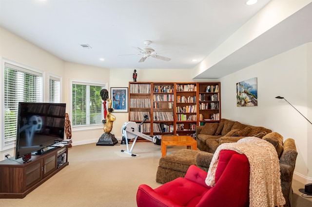 carpeted living room with ceiling fan