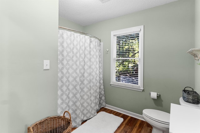 bathroom featuring hardwood / wood-style floors, a textured ceiling, and toilet