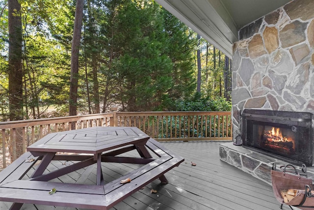 deck with an outdoor stone fireplace