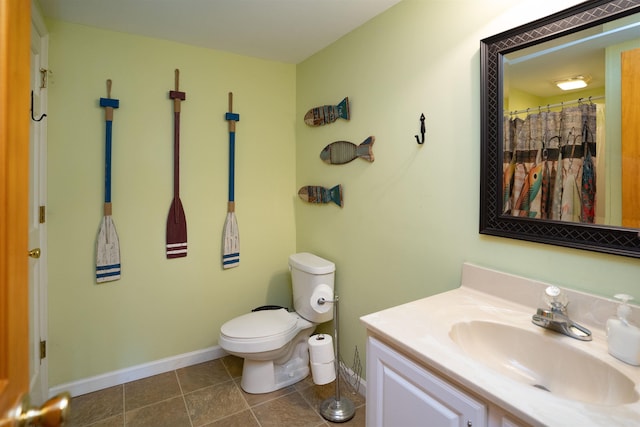 bathroom featuring vanity, tile patterned flooring, toilet, and walk in shower