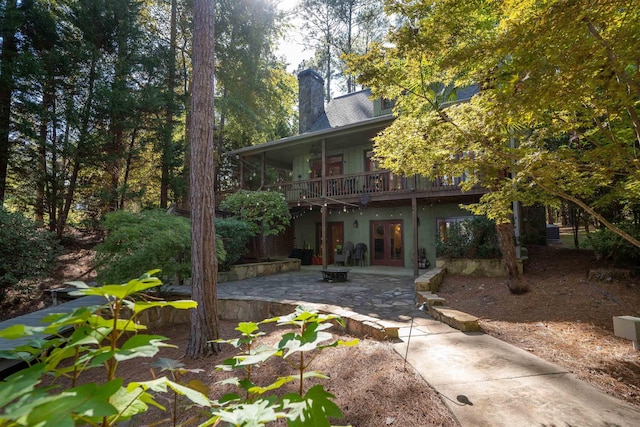 back of house featuring a wooden deck, a patio area, and an outdoor fire pit