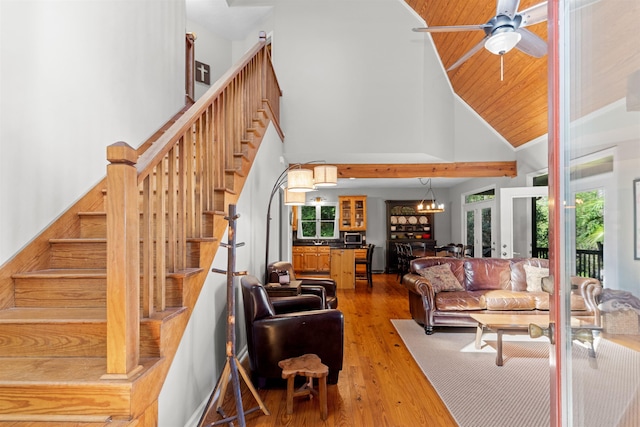 living room featuring ceiling fan with notable chandelier, hardwood / wood-style floors, and high vaulted ceiling