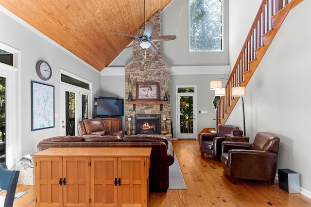 living room featuring ceiling fan, wooden ceiling, light hardwood / wood-style flooring, and a wealth of natural light