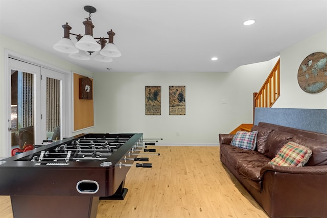 rec room with an inviting chandelier and light hardwood / wood-style floors