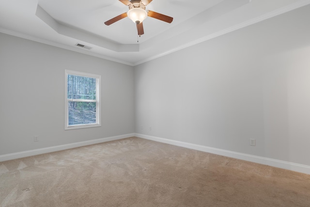 unfurnished room featuring a raised ceiling, baseboards, visible vents, and light carpet