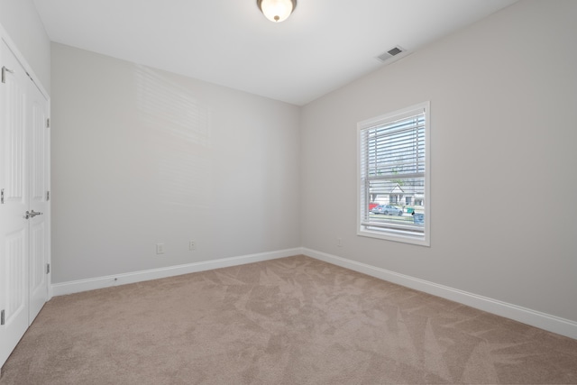 spare room featuring visible vents, baseboards, and carpet