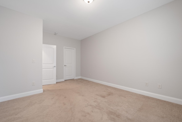 empty room with light colored carpet and baseboards