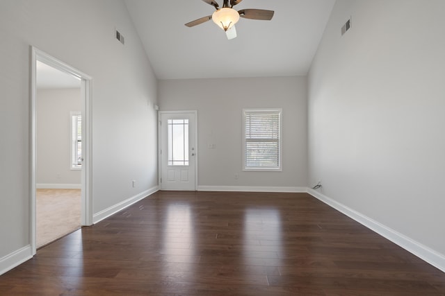 unfurnished room with a ceiling fan, visible vents, dark wood-style flooring, and baseboards