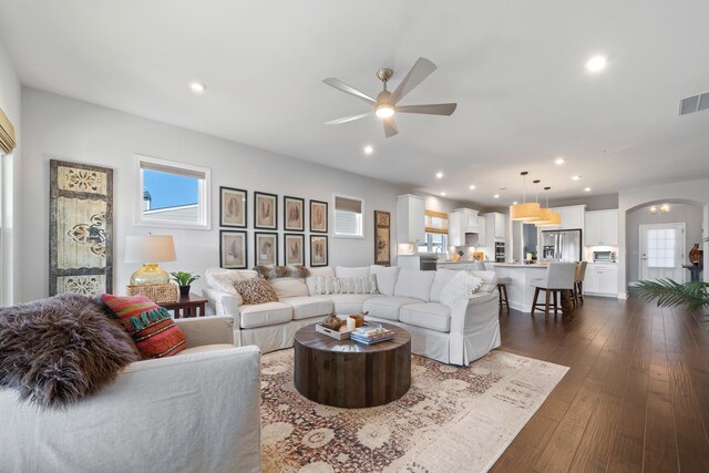 living room featuring dark wood-type flooring and ceiling fan