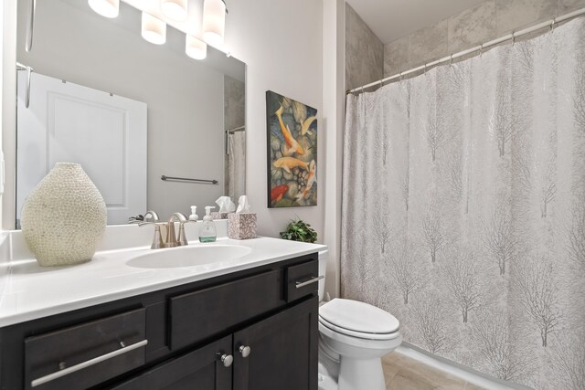 bathroom featuring vanity, tile patterned floors, and toilet