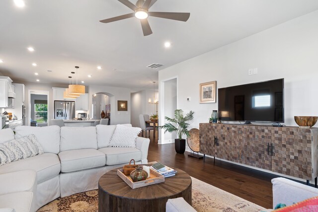 living room with dark wood-type flooring and ceiling fan