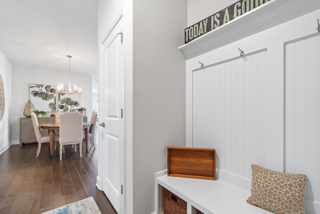 mudroom with dark hardwood / wood-style floors and an inviting chandelier