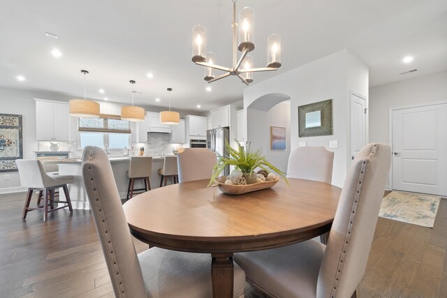 dining room featuring dark hardwood / wood-style flooring and an inviting chandelier